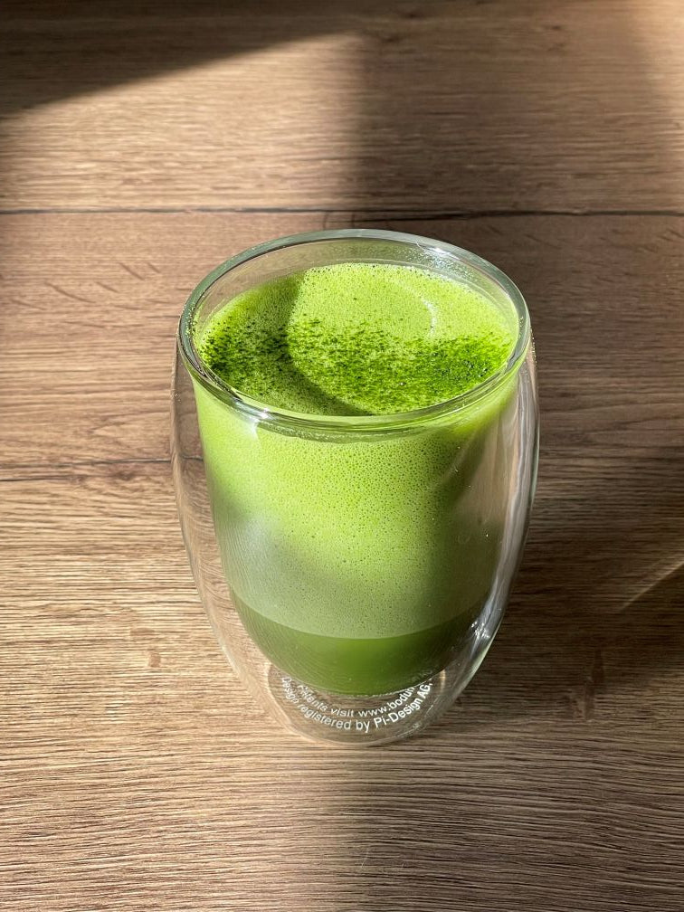 Fluffy matcha latte in a clear glass