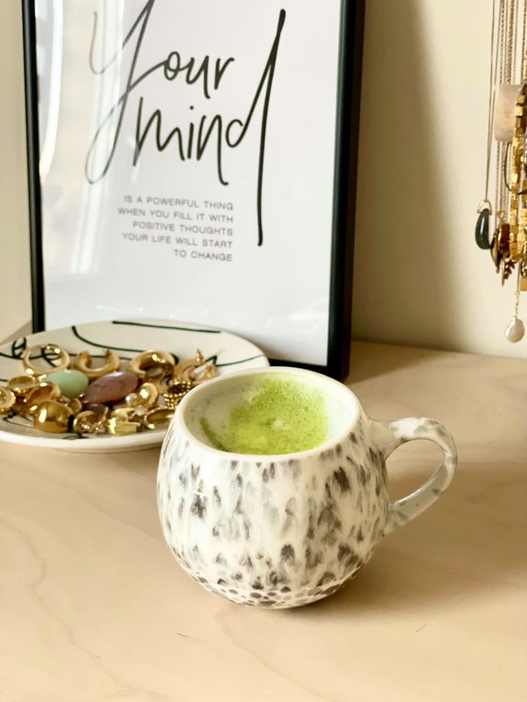Matcha latte in a cup, on a piece of furniture with jewels